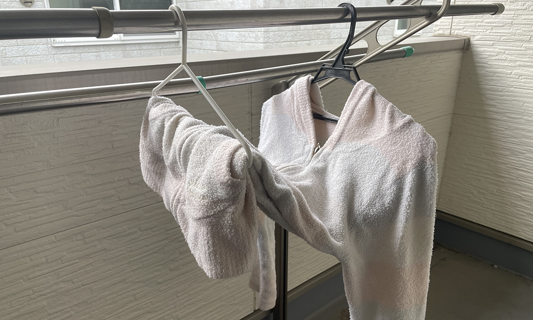 ハンガーを2本使いニットの重みを分散させて干している様子