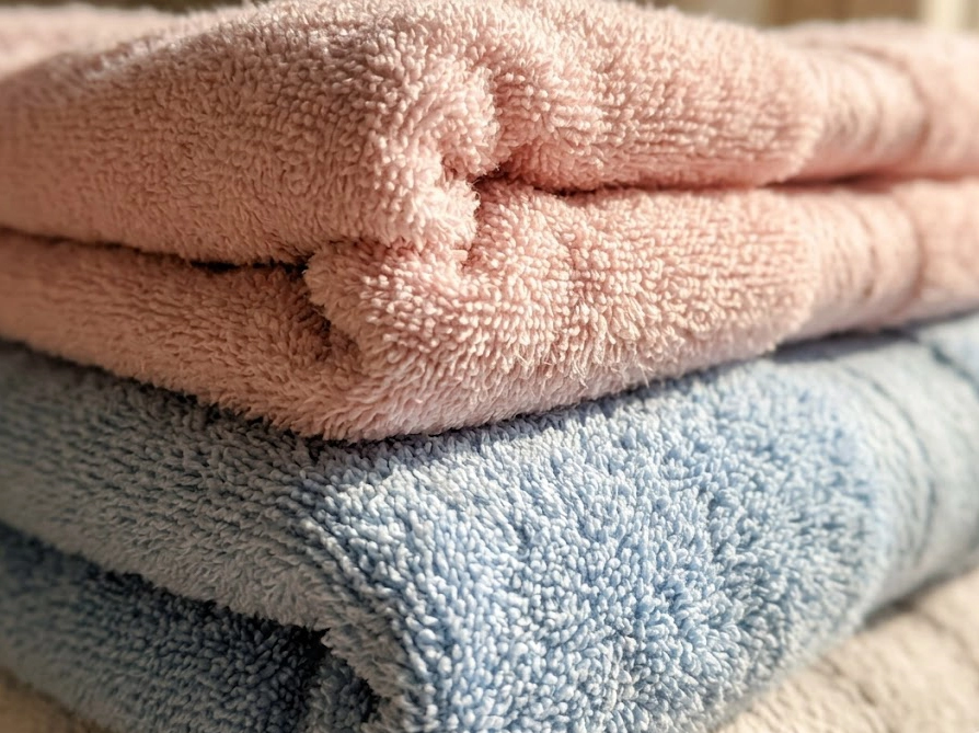 液体洗濯石鹸で洗い上がったふわふわのパステルカラータオルのクローズアップ