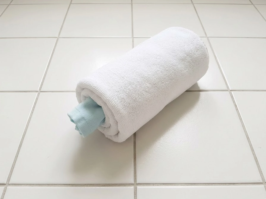 バスタオル脱水のやり方。白いバスタオルで衣類を海苔巻き状に巻いた状態