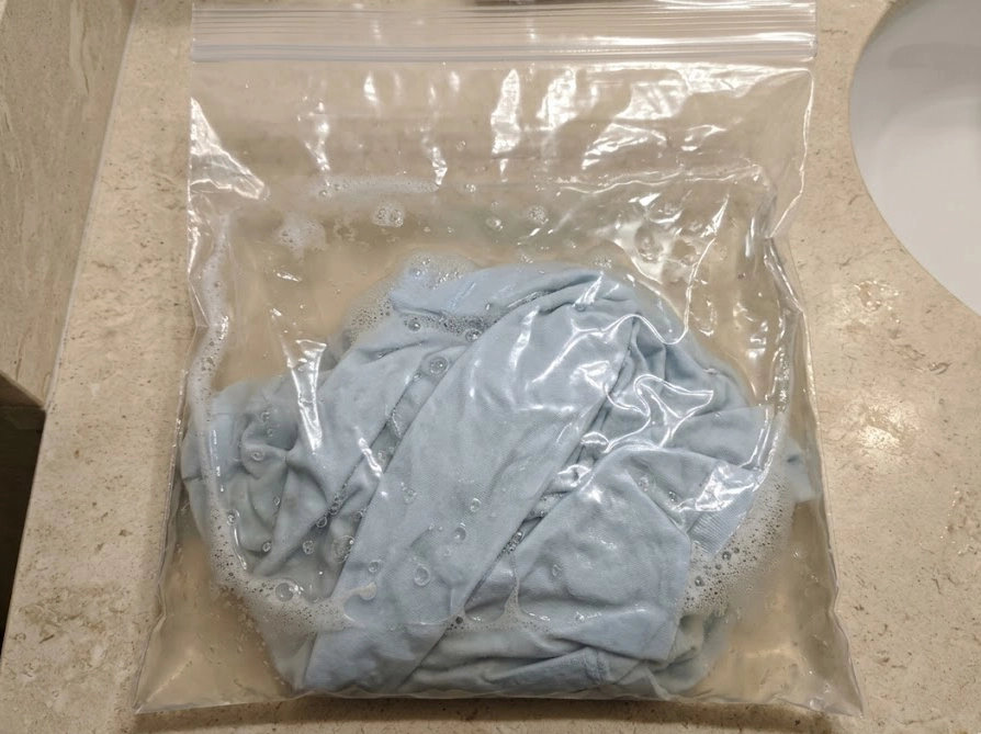 圧縮袋を使った簡易洗濯の様子。透明な袋の中に洗剤液と衣類を入れて洗う裏技