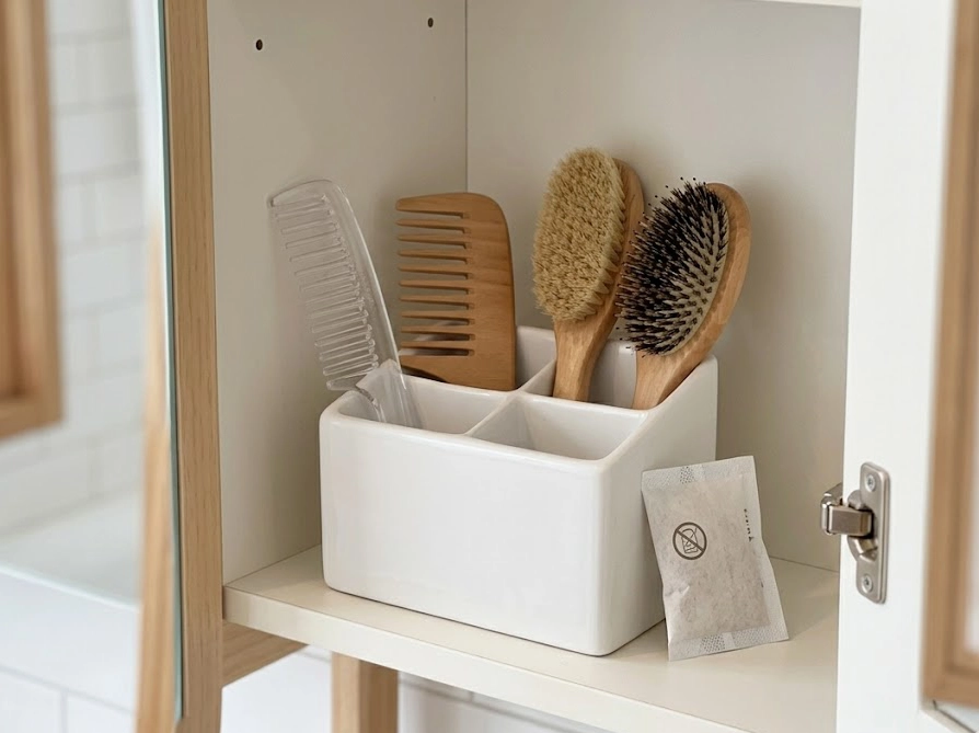 洗面台の仕切りケースにコームを立てて収納している様子