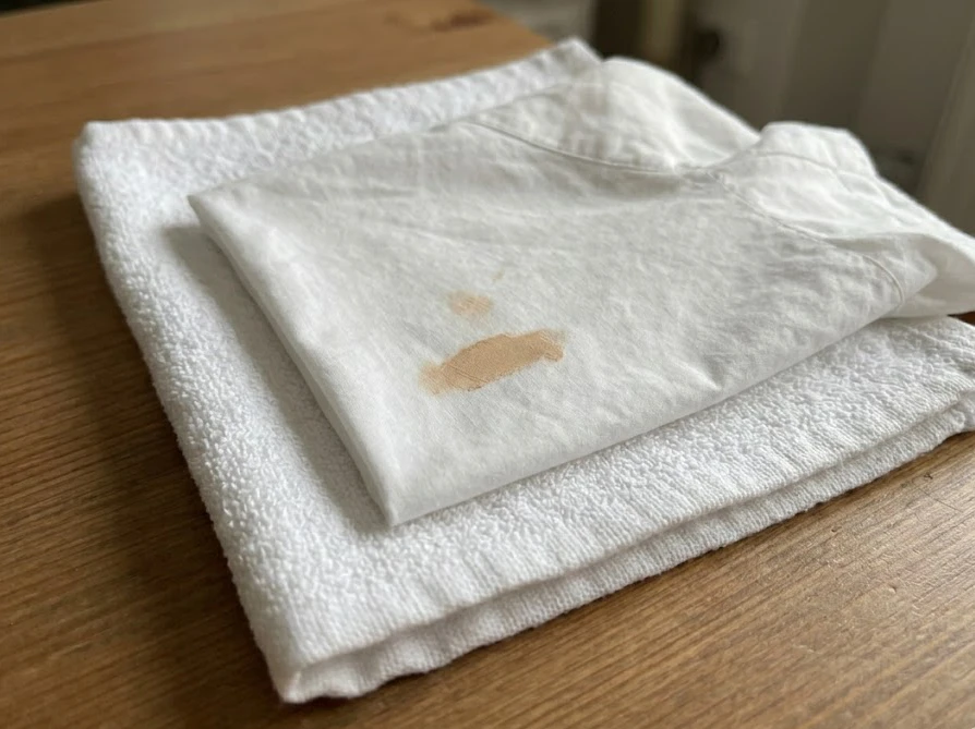 染み抜き作業のためにシミの裏側に白いタオルを敷いた様子
