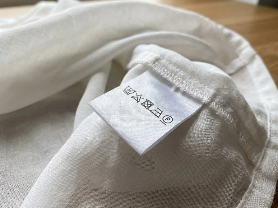 コーヒーのシミを落とす前に確認すべきデリケートな服の洗濯表示タグ