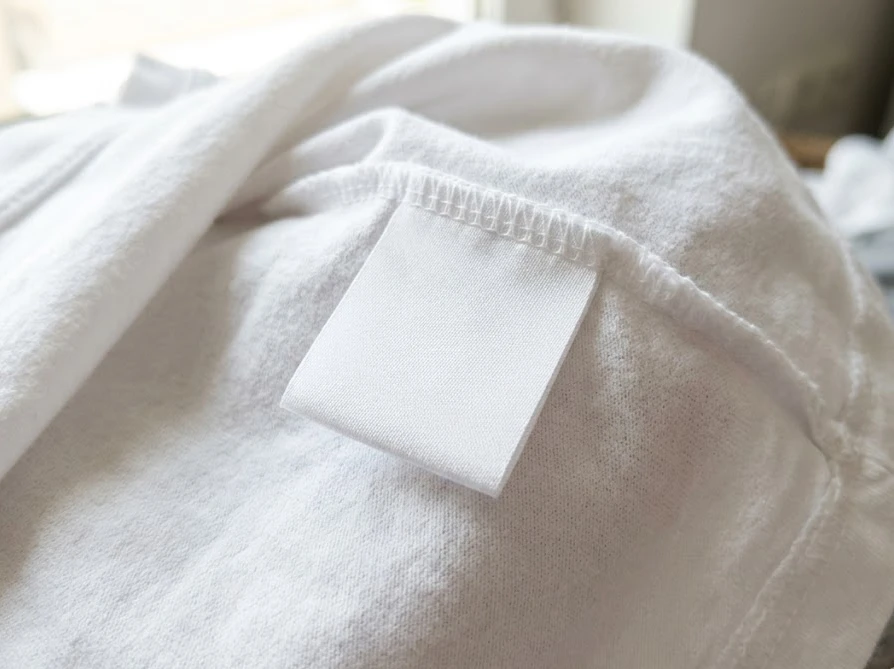 漂白剤を使えるかどうか確認するために、洋服の裏側に縫い付けられている洗濯表示タグ