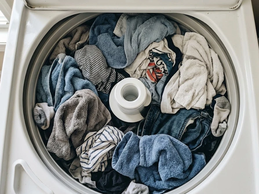 洗濯槽の中に衣類が隙間なく詰め込まれ、溢れそうになっている様子