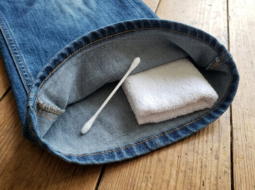 デニムの色落ちを防ぐため、裾の裏側などの目立たない場所でテストを行う様子