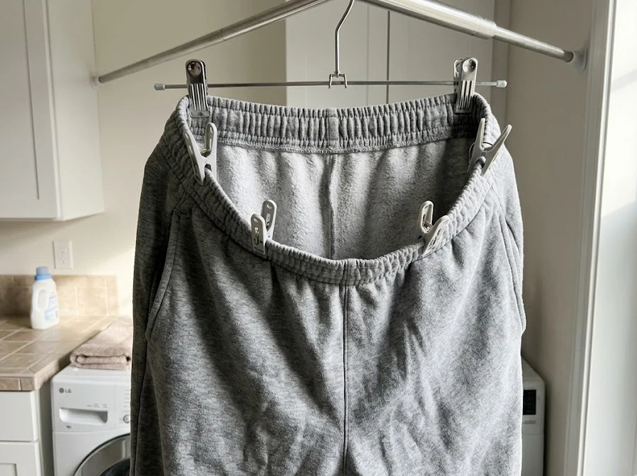 角型ハンガーを使い、ズボンのウエストゴムを広げて風の通り道を作る筒干しで早く乾かしている様子。