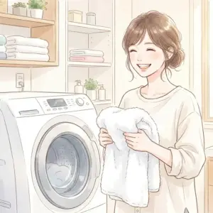 清潔なAQUA洗濯機の前で白いタオルを持ち、笑顔で立つ女性。洗濯槽をきれいに保つ様子