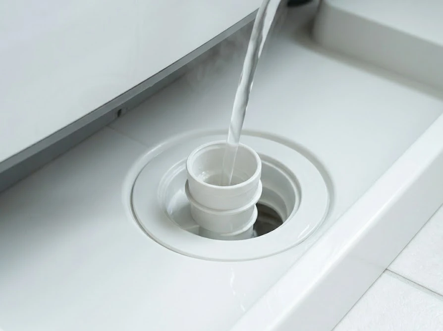 掃除が終わった後の排水口に、適温のぬるま湯を流して水漏れやつまりがないかテストする様子。