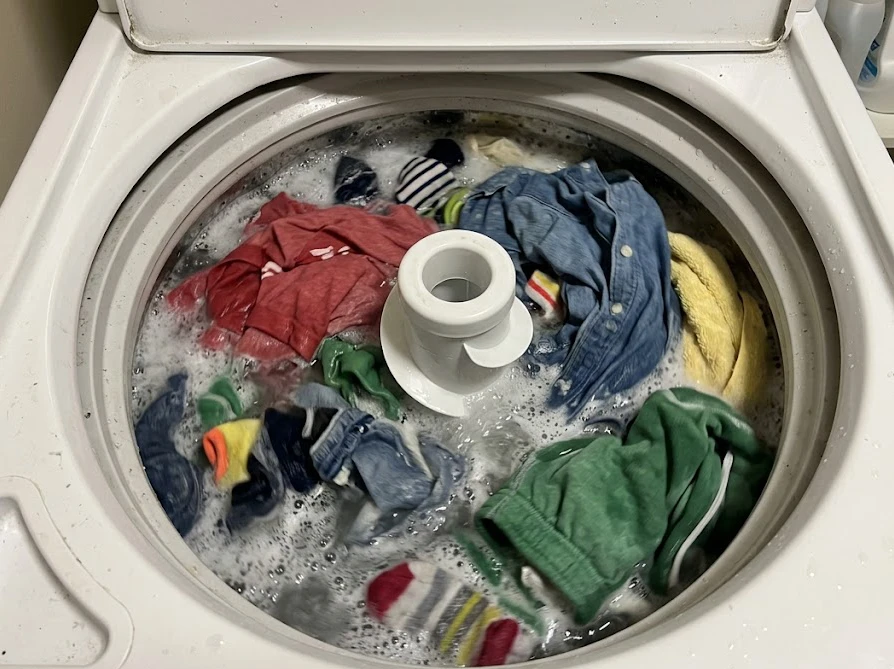 常温の水で洗われる洗濯機の中の衣類